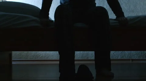 SILHOUETTE: Man gets up from a bed in the night then wears a slippers and goes Stock Footage 65173103