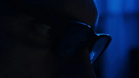 Silhouette of Man in Glasses Working at a Computer in a Dark Blue Room Close-Up Stock Footage 263583579