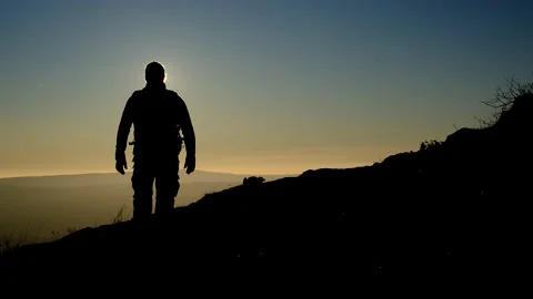 Silhouette of Man go hiking and look at the beautiful sunset view on mountain Stock Footage