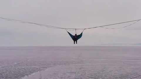 Silhouette of a man in a hammock mounted at high altitude. Video stock 108407335