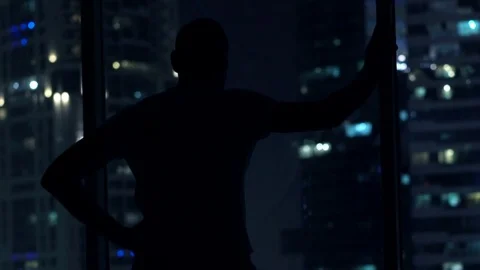 Silhouette of man having problems with sleep, waking up and standing by window  Stock Footage 72027886