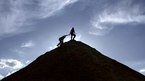 Silhouette of a man helps a partner Stock-Footage 131626440