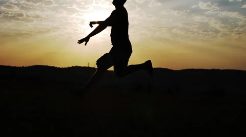 Silhouette of a Man Jumping on a Background of the Sun Stock Footage 67343768