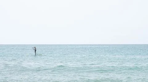 Silhouette of a man kayaking in the distance on the waters of the Mediterrane Stock Photos