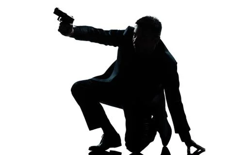 Silhouette man kneeling aiming gun Stock Photos