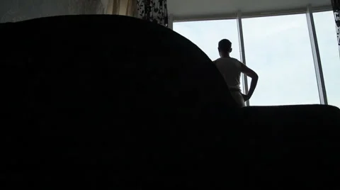 Silhouette of  man looking out the window in the flat Stock Footage 45794458