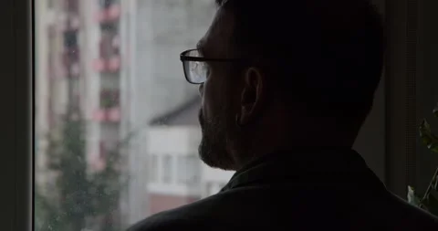 A silhouette of a man looking out of a window Stock Footage 331537051