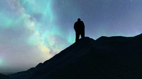 Silhouette of man looking up at starry sky on top of mountain Stock Footage 242497159