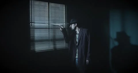 Silhouette of a man looking through the window in a dark room. Film noir Видео 275823970