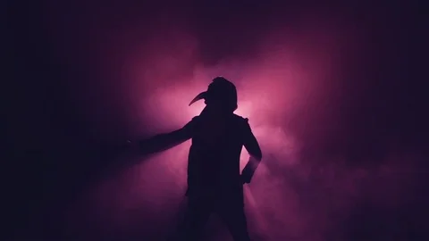 Silhouette of man in mask dancing in smoke Stock Footage 80598102
