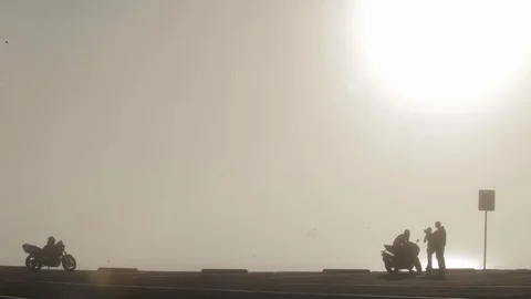 Silhouette of a Man on Motorcycle talking to another Person Stock Footage 114018799
