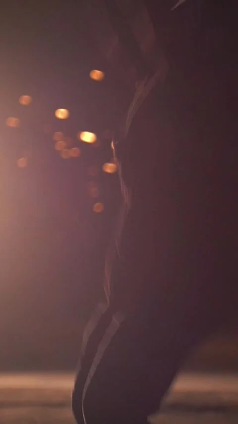 Silhouette of man performing martial elements through the sparks from grinder at Stock Footage 346755378