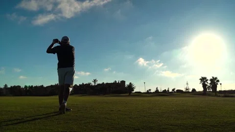 Silhouette of a man performing playing golf on a golf club course. He makes.. Stock Footage 252603915