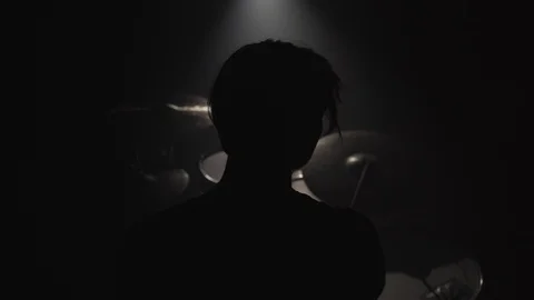 Silhouette of man playing drums in dark Stock Footage 104047572