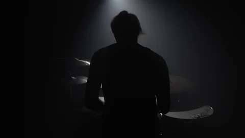 Silhouette of man playing drums in dark Stock Footage 104047873