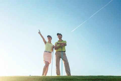 Silhouette of a man pointing while standing next to his partner Stock Photos