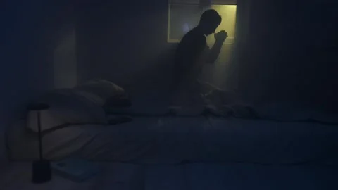 Silhouette of a man praying in dark space with holy backlight. Video stock 320180005