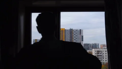 Silhouette of a man putting on his jacket on the background of a big city Stock Footage 99332069
