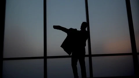 Silhouette Man Putting on Suit Jacket Against Glass Window 库存影片 121010053