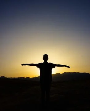 Silhouette of Man Raising His Hands or Open Arms When the Sun Rises . Stock Photos