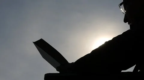 Silhouette of man reading book with bright sun background Video stock 47734516