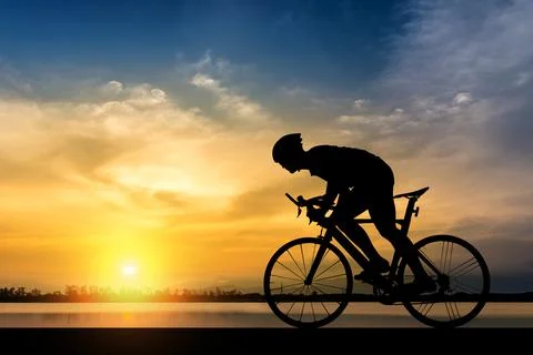 Silhouette of man ride a bicycle in sunset background Stock Photos