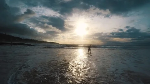 Silhouette of a man running out of the ocean at sunset Stock-Footage 88109317