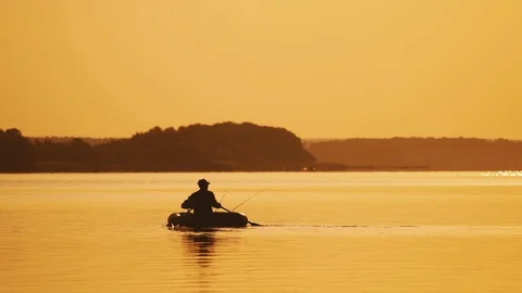 Two men fishing from a boat at sunset on, Stock Video