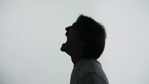 Silhouette of a man shouting in rage during a loud emotional outburst Vídeo Stock 343140998