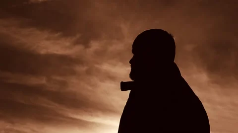 Silhouette of man smoking in the sunset Vídeos de archivo 45297367