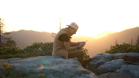 Silhouette man spread hand on top of a mountain enjoying sunset. silhouette of Stock-Footage 98569987