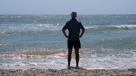 Silhouette of a man standing and looking towards the sea Stock Footage 66423537