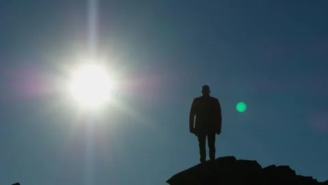 Silhouette of a man standing on a hill facing the sun. Shooting from a drone. Stock-Footage 247086355
