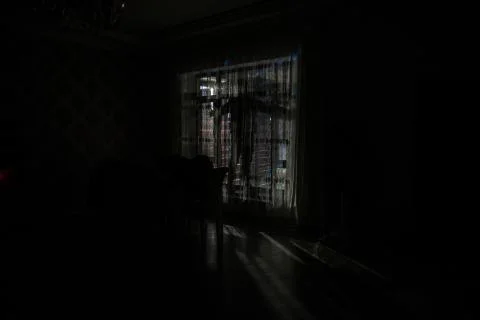 Silhouette of a man standing at a window inside the room. Fantasy picture wit Stock Photos