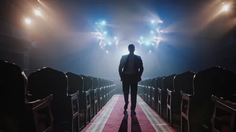 Silhouette of Man in Suit Walking on Red Carpet Aisle in Empty Theater Hall 스톡 동영상 337882542