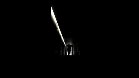 The silhouette of a man in a suit walks down a dark corridor. Stock Footage 318569352