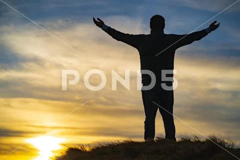 The silhouette of the man on the sunset background Stock Photos