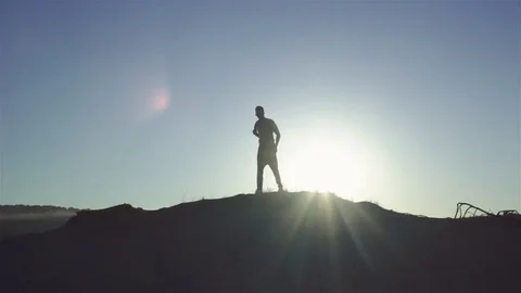 Silhouette of a man at sunset Stock Footage 77454137