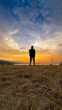 Silhouette of Man at Sunset by the Lake Stock Photos