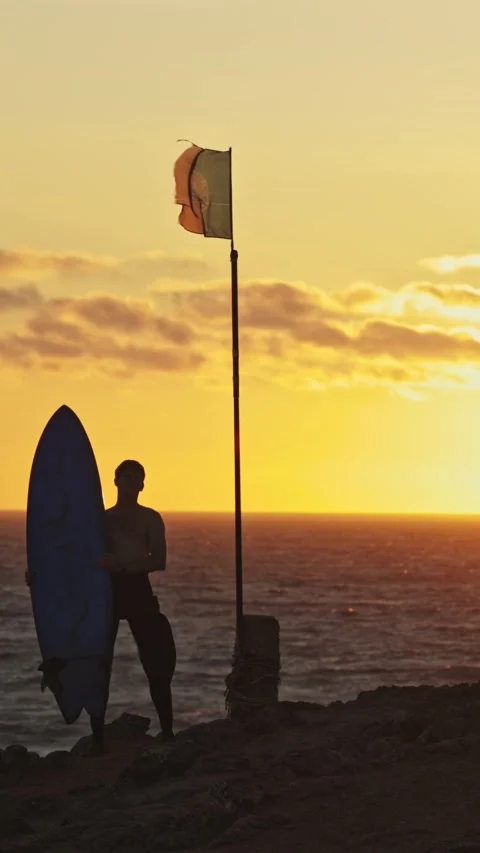 Silhouette of a man surfer against the backdrop of the ocean and sunset - the Stock Footage 328670568