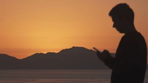 Silhouette of Man talking on the phone when sun rising up Видео 75745237