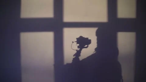 Silhouette of a man testing the movements of a gimbal with a camera in the Stock Footage 145803075