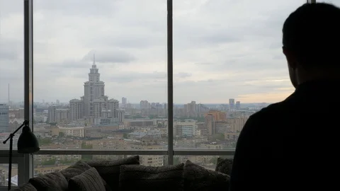 Silhouette of man thoughtfully looking at cloudy city Stock Footage 103199966