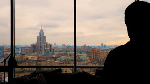 Silhouette of man thoughtfully looking at cloudy city Stock Footage 103200086