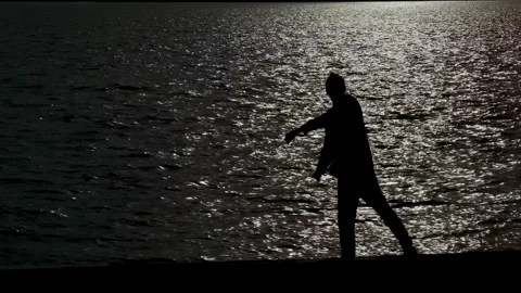 Silhouette of Man Throwing Stone into Lake Palic at Sunset 库存影片 336178646