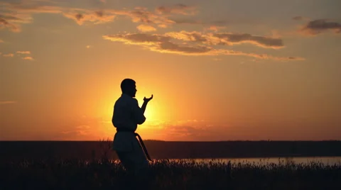 Silhouette of man training karate at sunset Stock Footage