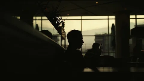 Silhouette of a man using his smartphone and listening to music Stock Footage 84383433