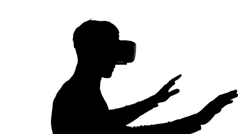 Silhouette of a man in virtual reality glasses watching a video 库存影片 83906997