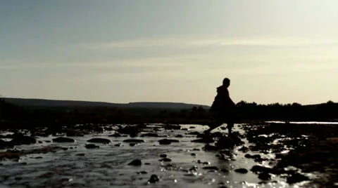 Silhouette of man walking across stream, slow motion Vídeos de archivo 10842382
