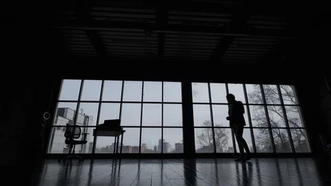 Silhouette of a man walking around a spacious office. Stock Footage 107768557